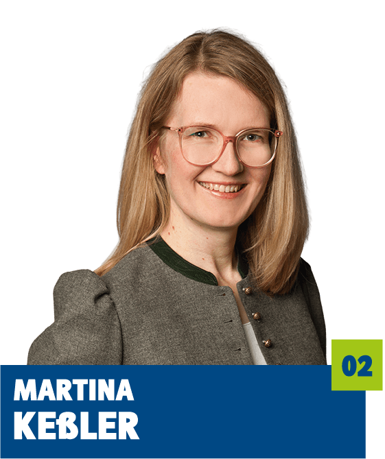 Professionelles Porträt von Martina Keßler vor dunklem Hintergrund. Sie trägt eine graue Trachtenjacke mit grünem Kragen und eine Brille und lächelt freundlich in die Kamera. Der offene Blick und das gepflegte Erscheinungsbild vermitteln Kompetenz, Seriosität und eine sympathische, vertrauensvolle Ausstrahlung und eignen sich sehr gut für die persönliche Vorstellung im beruflichen oder organisatorischen Kontext.