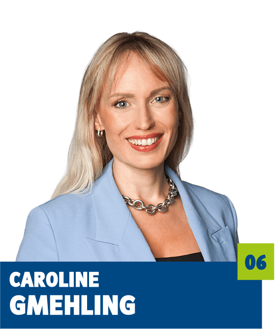 Professionelles Porträt von Caroline Gmehling vor dunklem Hintergrund. Sie trägt einen hellblauen Blazer, ein dunkles Top und eine markante Kette und lächelt offen in die Kamera. Der direkte Blick und das gepflegte Erscheinungsbild vermitteln Kompetenz, Selbstbewusstsein und eine moderne, vertrauensvolle Ausstrahlung und eignen sich sehr gut für die persönliche Vorstellung im beruflichen oder organisatorischen Kontext.