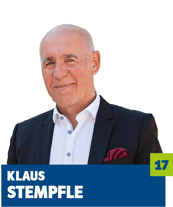 Professionelles Porträt von Klaus Stempfle vor dunklem Hintergrund. Er trägt ein weißes Hemd, ein dunkles Sakko und ein farblich abgestimmtes Einstecktuch. Der ruhige Blick und das selbstbewusste Lächeln vermitteln Erfahrung, Seriosität und eine souveräne Ausstrahlung und eignen sich ideal für die persönliche Vorstellung im beruflichen oder organisatorischen Kontext.