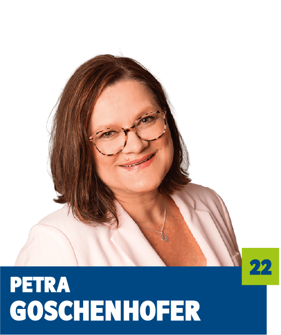 Professionelles Porträt von Petra Goschenhofer vor dunklem Hintergrund. Sie trägt einen hellen Blazer, eine dezente Kette und eine Brille und lächelt freundlich in die Kamera. Die weiche Farbwahl und der offene Blick vermitteln Kompetenz, Vertrauen und eine sympathische, nahbare Ausstrahlung und eignen sich ideal für die persönliche Vorstellung im beruflichen oder organisatorischen Kontext.