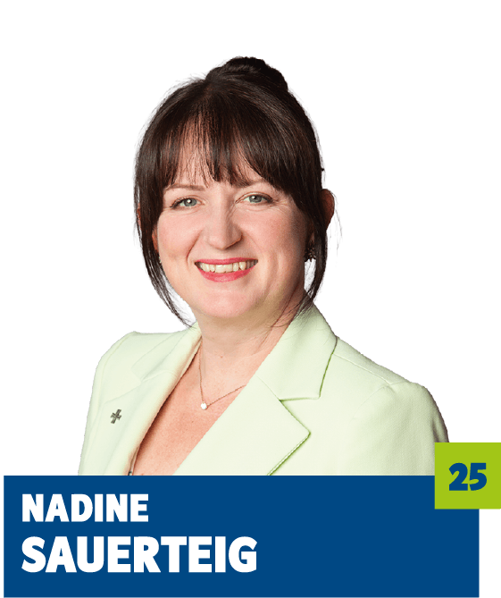 Professionelles Porträt von Nadine Sauerteig vor dunklem Hintergrund. Sie trägt ein hellgrünes Sakko und eine feine Halskette und lächelt freundlich in die Kamera. Der offene Blick und die helle Farbwahl vermitteln Vertrauen, Kompetenz und eine angenehme Nahbarkeit und eignen sich sehr gut für die persönliche Vorstellung im beruflichen oder organisatorischen Kontext.