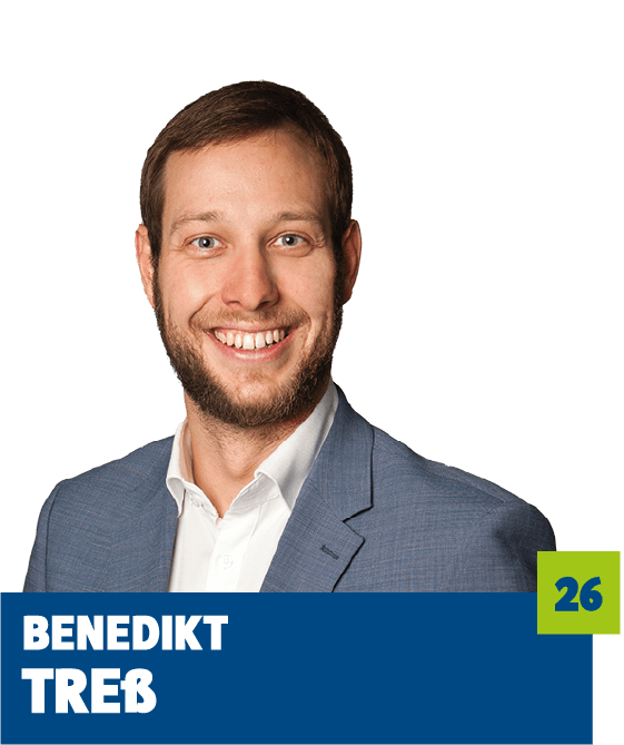 Professionelles Porträt von Benedikt Treb vor dunklem Hintergrund. Er trägt ein weißes Hemd und ein blaues Sakko und lächelt offen in die Kamera. Der freundliche Gesichtsausdruck und der direkte Blick vermitteln Kompetenz, Offenheit und eine moderne, sympathische Ausstrahlung und eignen sich sehr gut für die persönliche Vorstellung im beruflichen oder organisatorischen Kontext.